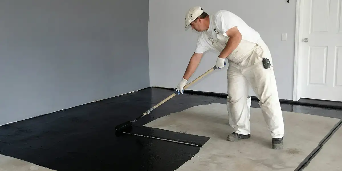 basement waterproofing professional applying waterproof coating to protect a basement floor in Jacksonville, FL