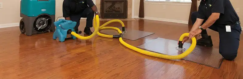 emergency water removal technicians extracting standing water from a home using professional equipment in Jacksonville, FL